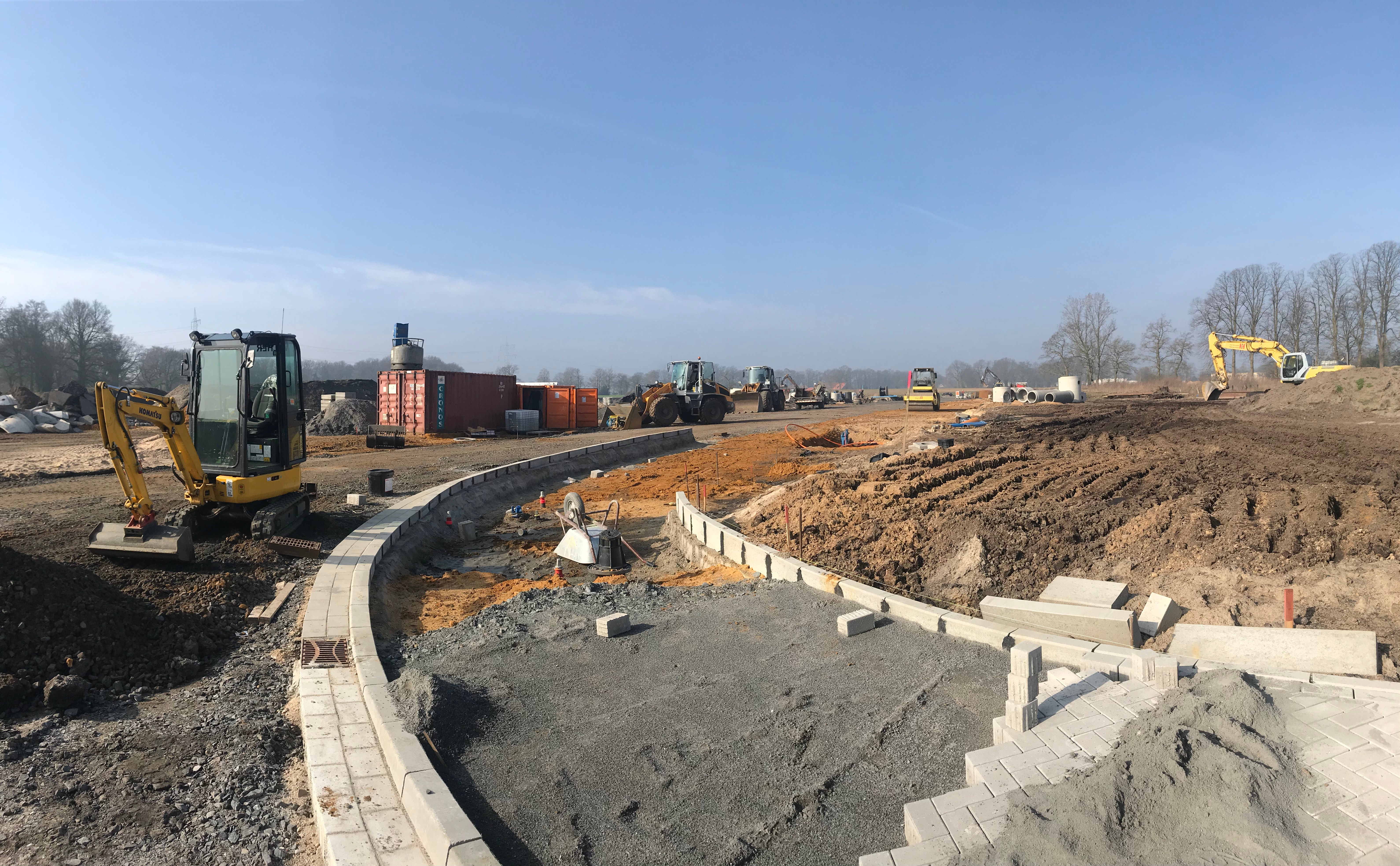 Das Bild zeigt die Bauarbeiten des neuen Gewerbegebietes "An der Eßseite" mit Baggern, Baumaschinen und frisch angelegten Straßenbereichen. Die Aufnahme zeigt weitläufige Erdarbeiten unter blauem Himmel.