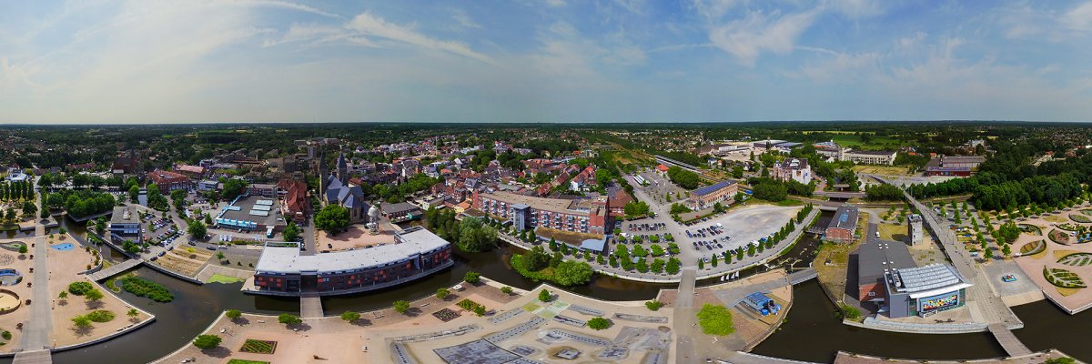 Panorama-Luftaufnahme der Stadt Gronau mit Gebäuden, Straßen, Wasserflächen und Grünanlagen. Die Innenstadt sowie umliegende Bereiche sind aus großer Höhe zu erkennen.